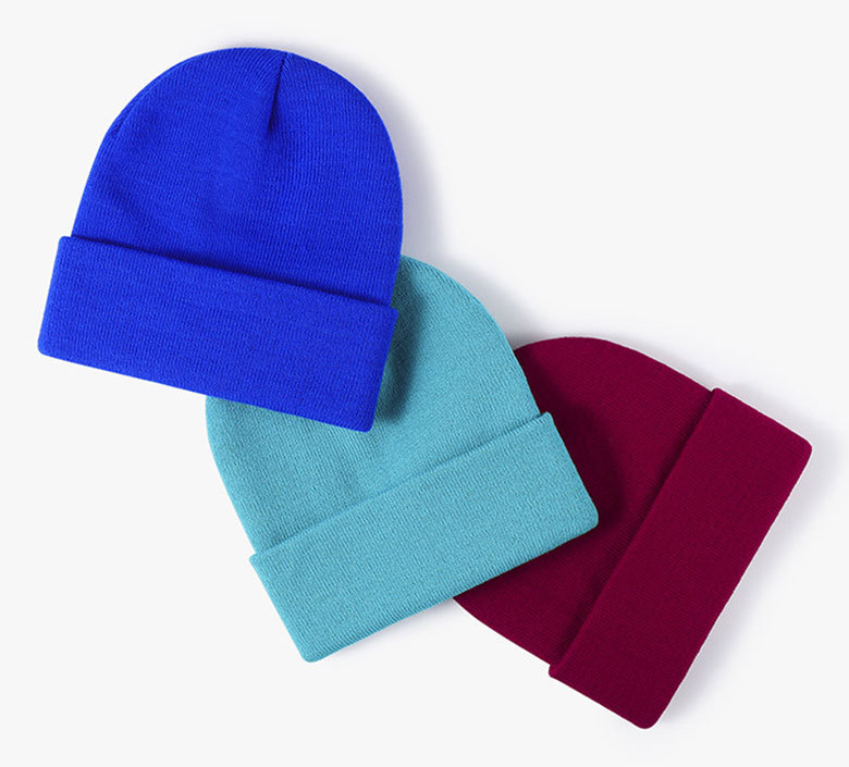 royal blue, cyan and maroon rib-knit cuffed beanies overlapped diagonally on white