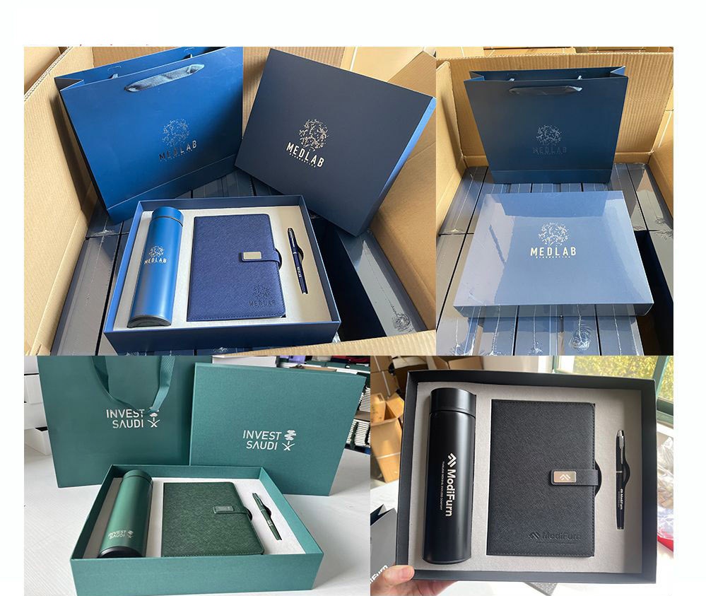 Packing-stage four-panel collage: royal blue, sage green and black configurations of the tumbler, notebook and pen trio sitting inside open corrugated export cartons with matching carrier bags and shrink-sleeved lids, each panel showing a different client's sample print