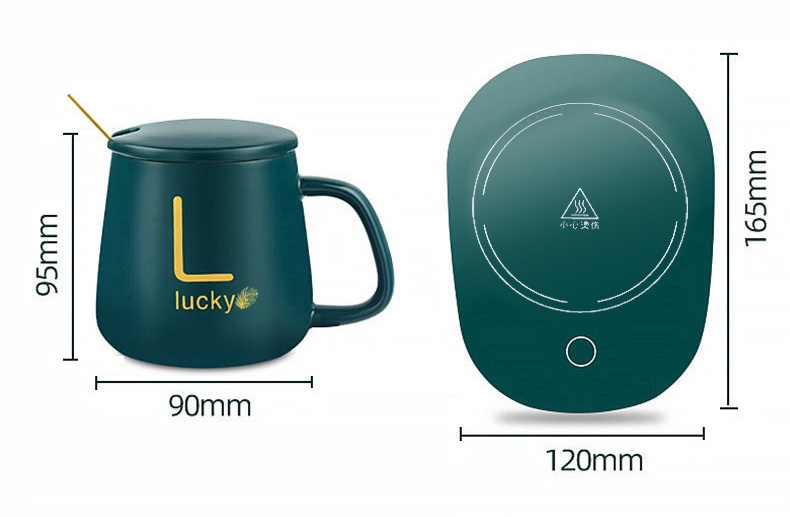 Dimensioned specification graphic on white: matte teal lidded mug with gold monogram sample shown three-quarter next to a top-down teal warming pad marked with a heating-zone circle, heat caution triangle and touch button, with printed millimetre measurements around both items