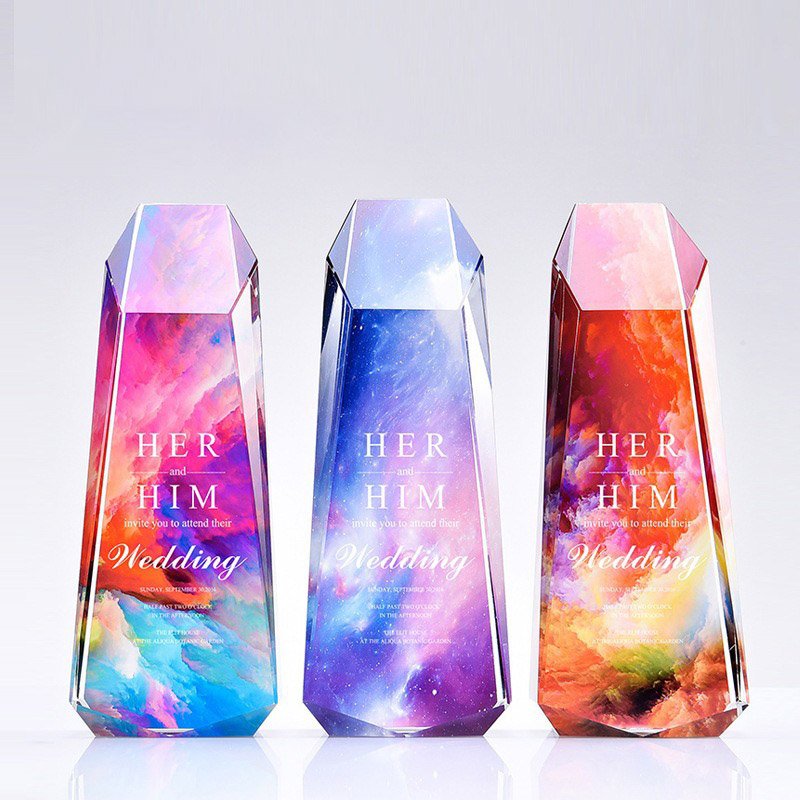 three faceted crystal-style acrylic plaques standing side by side in pink blue and orange artwork variants